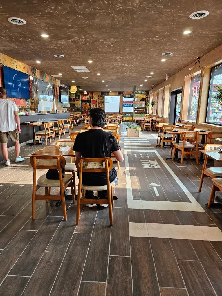 The ASF dining room: wooden tables and cane-back chairs along a painted street crosswalk running down the floor.